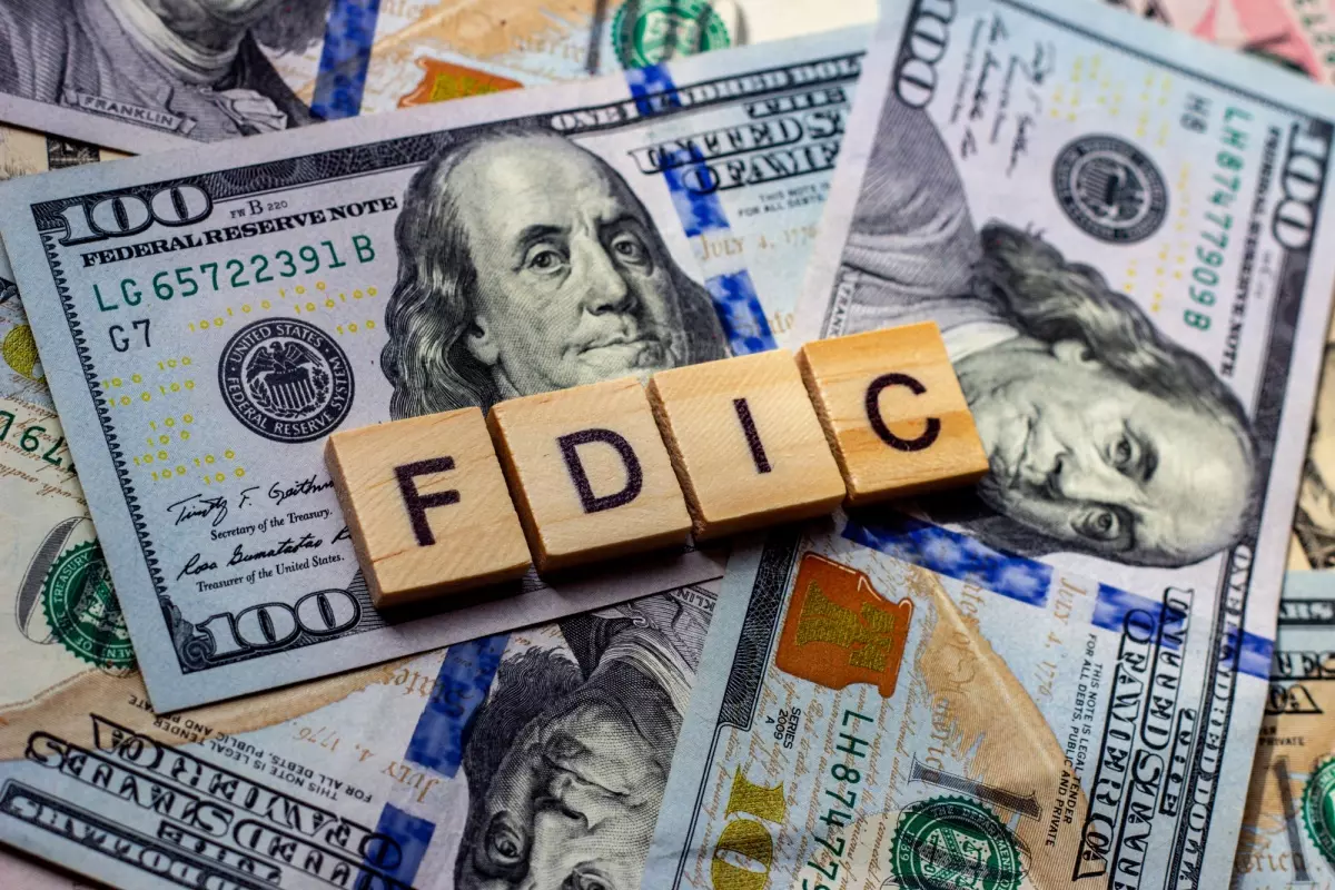 Wooden blocks spelling FDIC on top of $100 bills